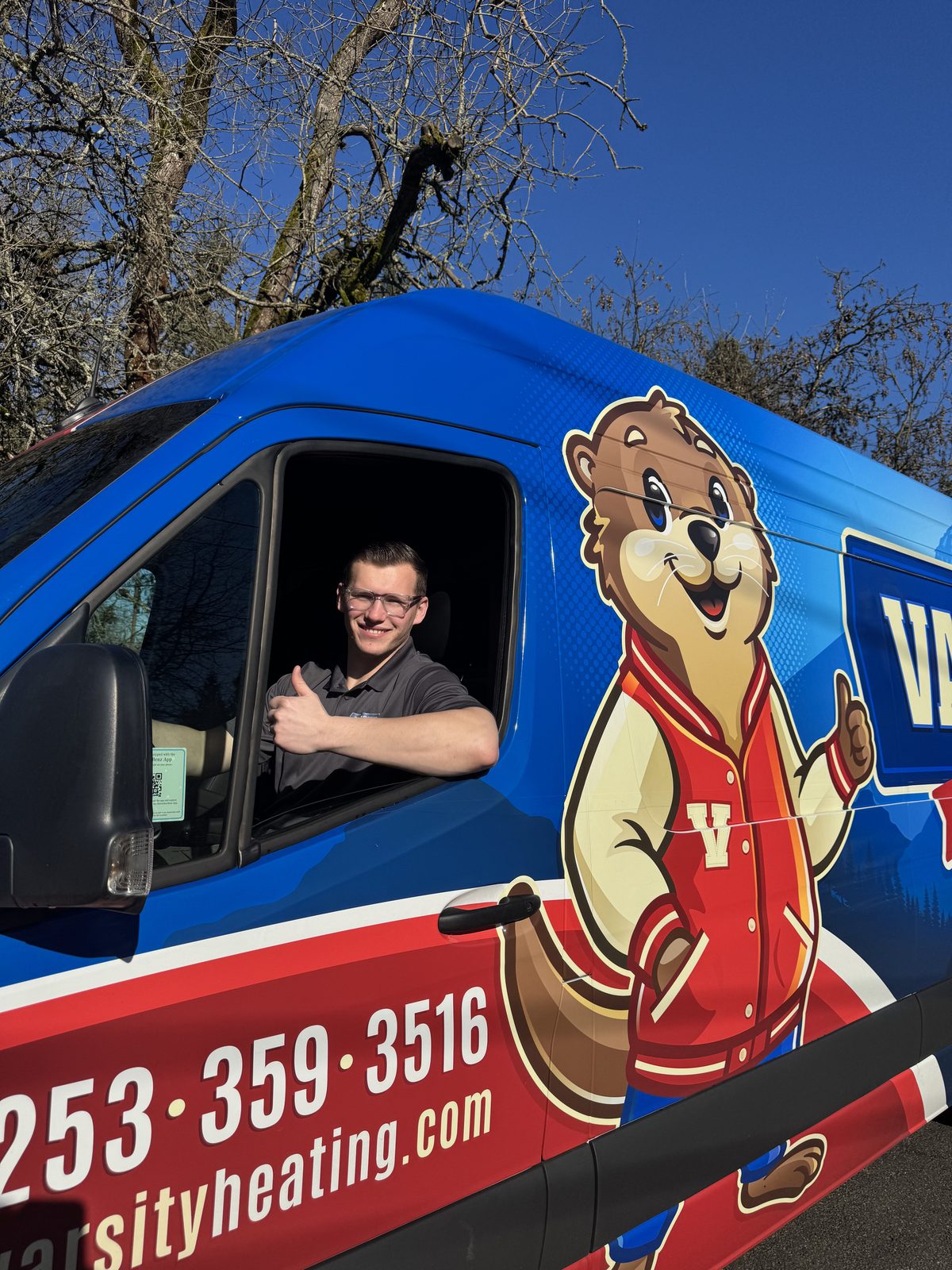 Jake from Varsity giving a thumbs up from the driver's seat of a Varsity van